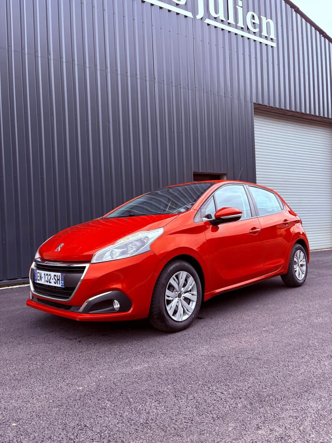 Peugeot 208 rouge devant le garage