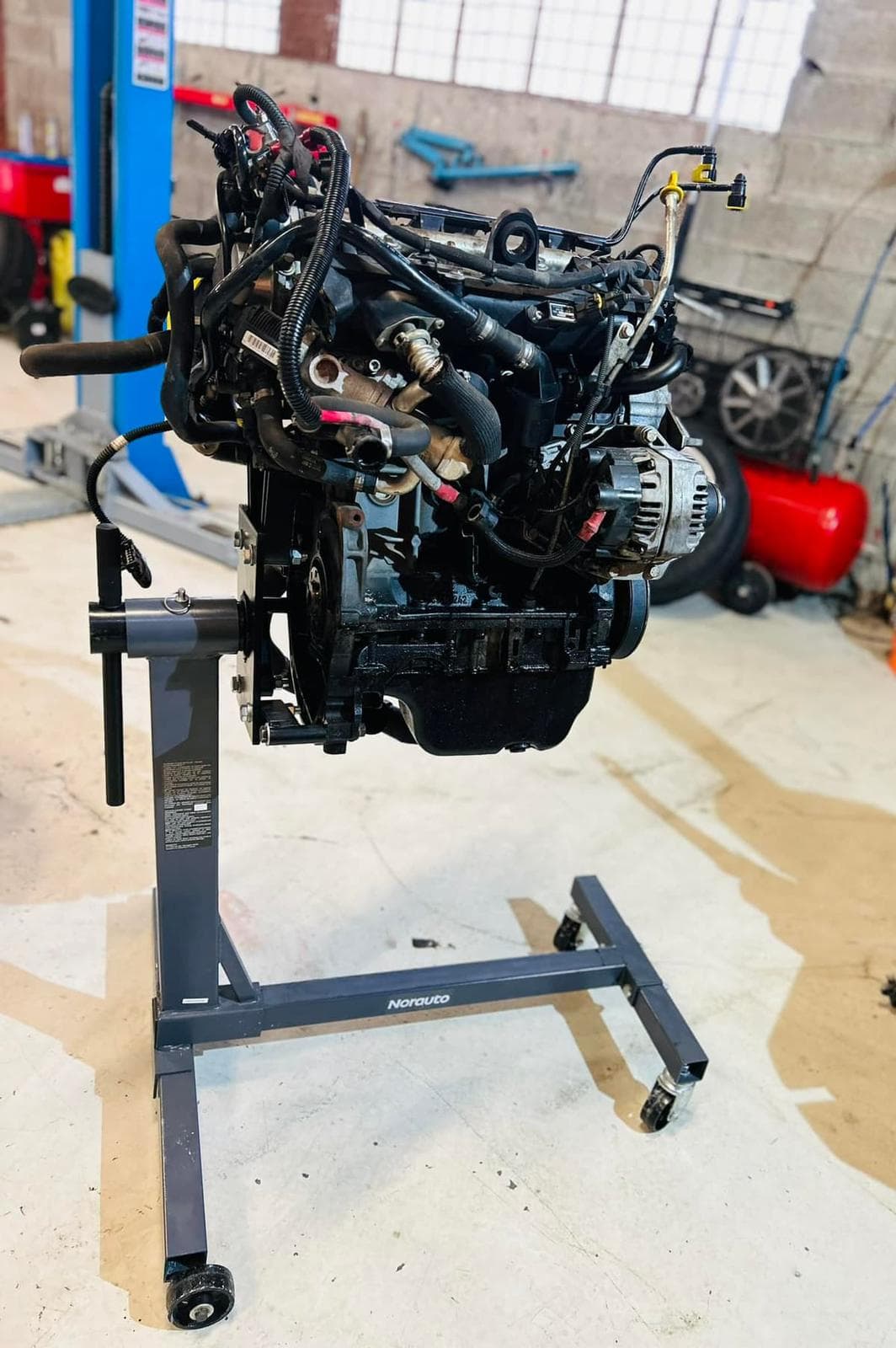 Bloc moteur complet sorti sur support dans l'atelier Automobiles Julien